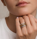 Gold layered interlocking ring with cubic zirconia details on model hand, stacked band design