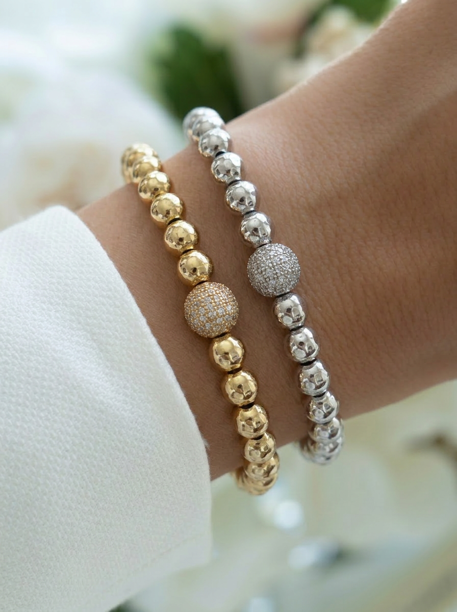 gold and silver beaded stretch bracelets stacked on wrist, cubic zirconia crystal ball bracelet, layered jewellery look