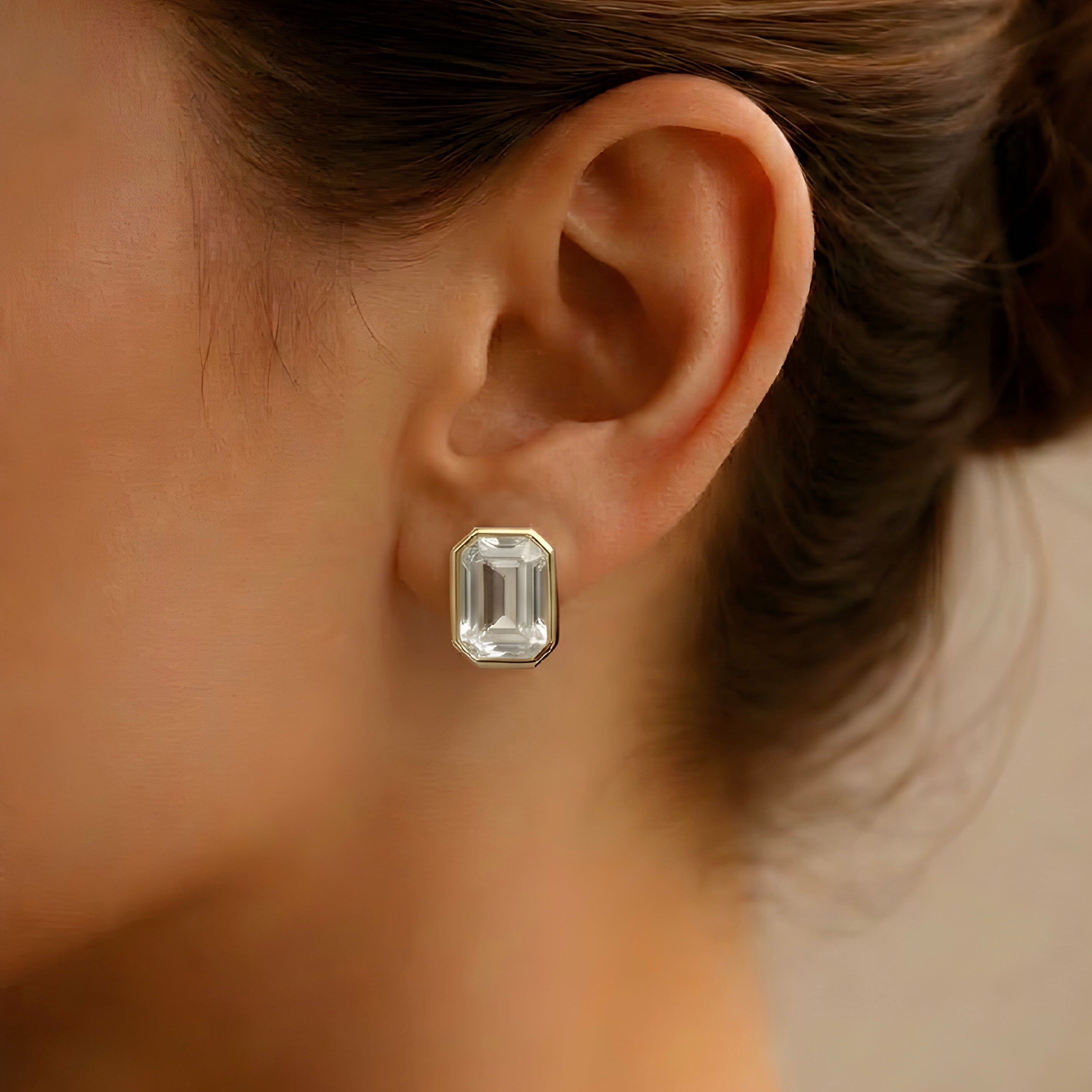 Gold crystal stud earrings on ear, octagon clear gemstone statement studs
