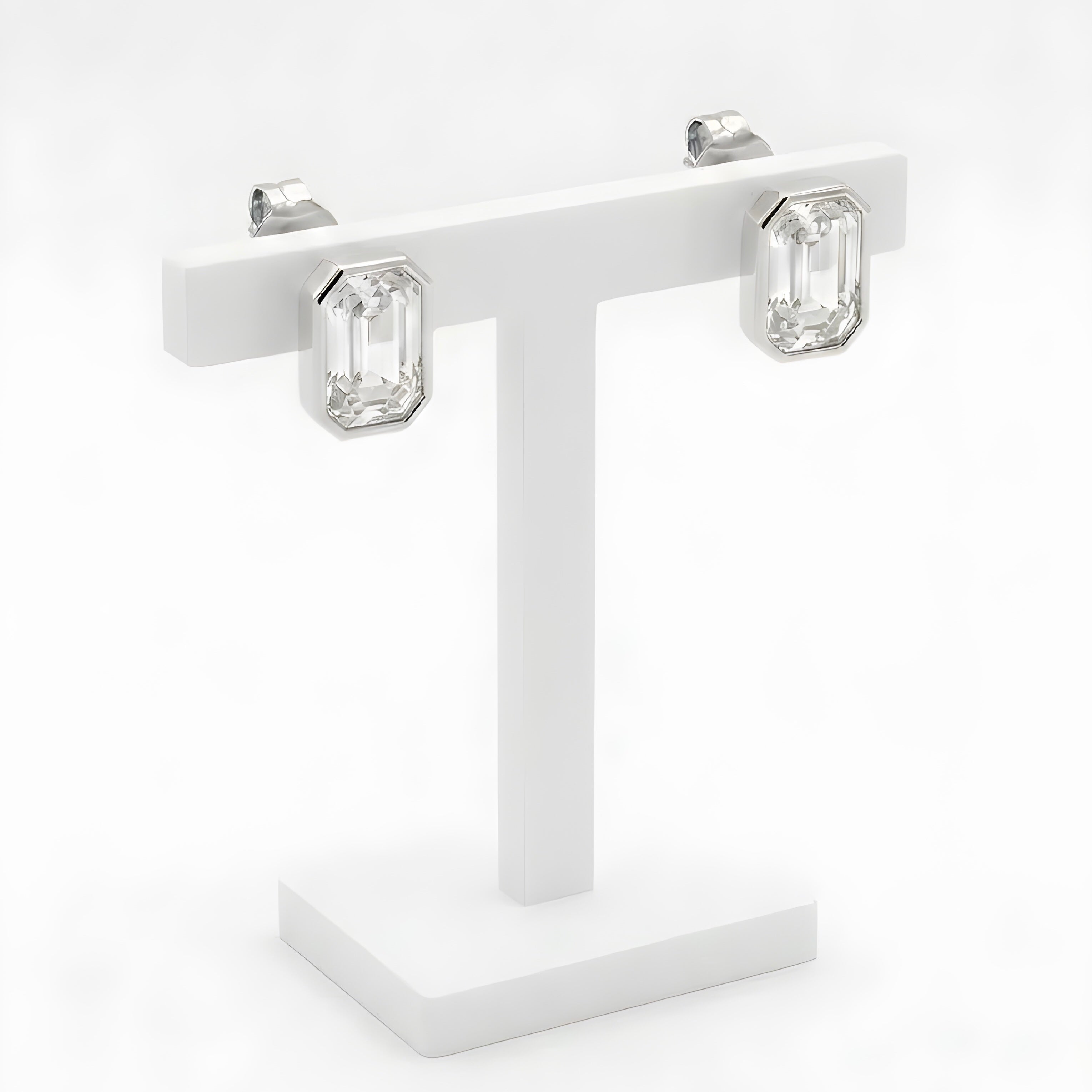 Gold octagon crystal stud earrings on white display stand