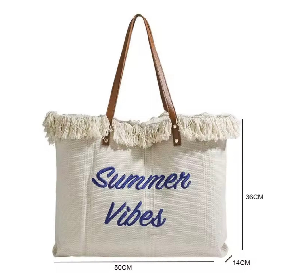 Beige tote bag with 'Summer Vibes' text and fringes, dimensions displayed.