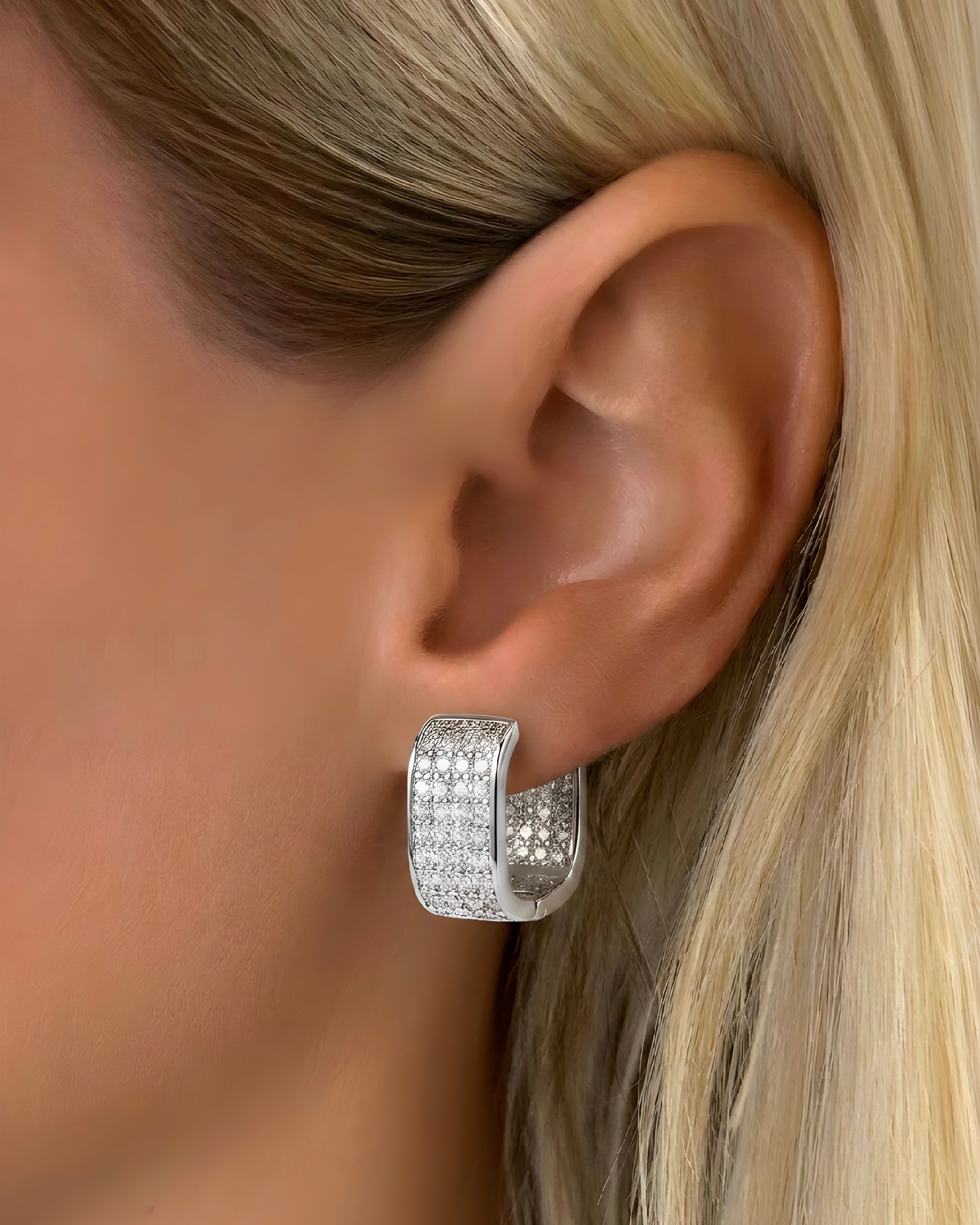 Silver pavé square hoop earrings worn on ear, chunky huggie style with crystal detailing
