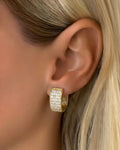 Gold pavé square hoop earrings worn on ear, chunky huggie style with crystal detailing