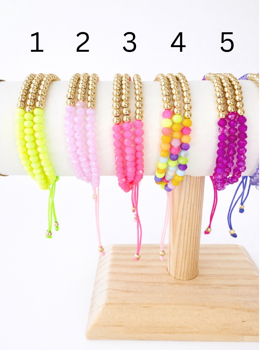 Colorful beaded bracelets on a wooden stand