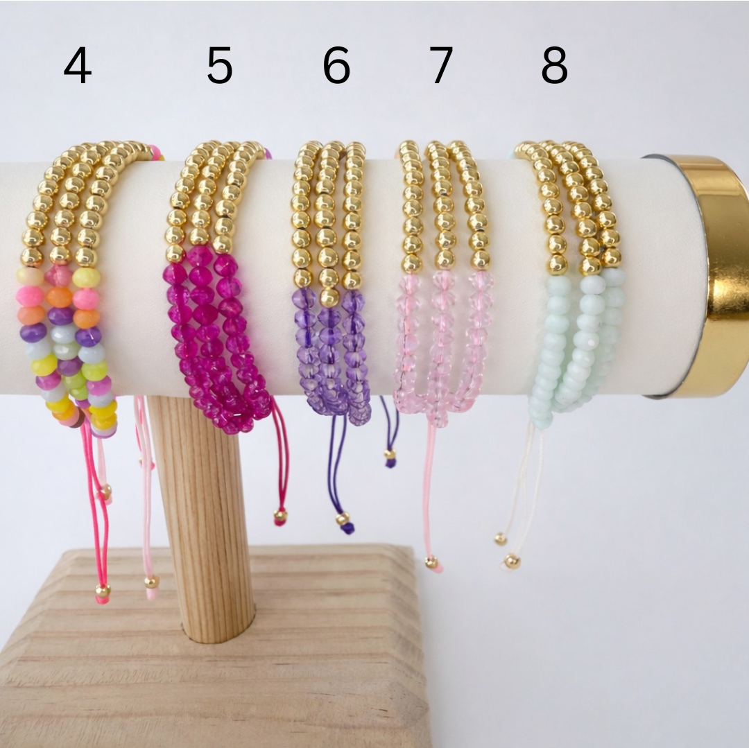 Set of colorful beaded bracelets on a wooden stand